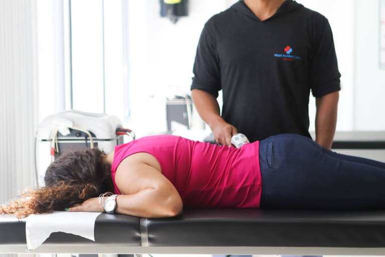 Clinic worker examining patient's back pain